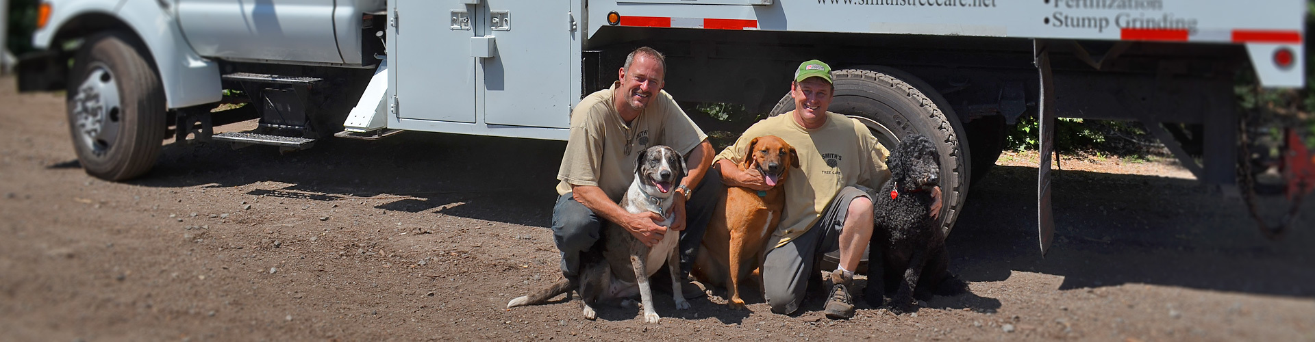 Owners with dogs in front of company truck